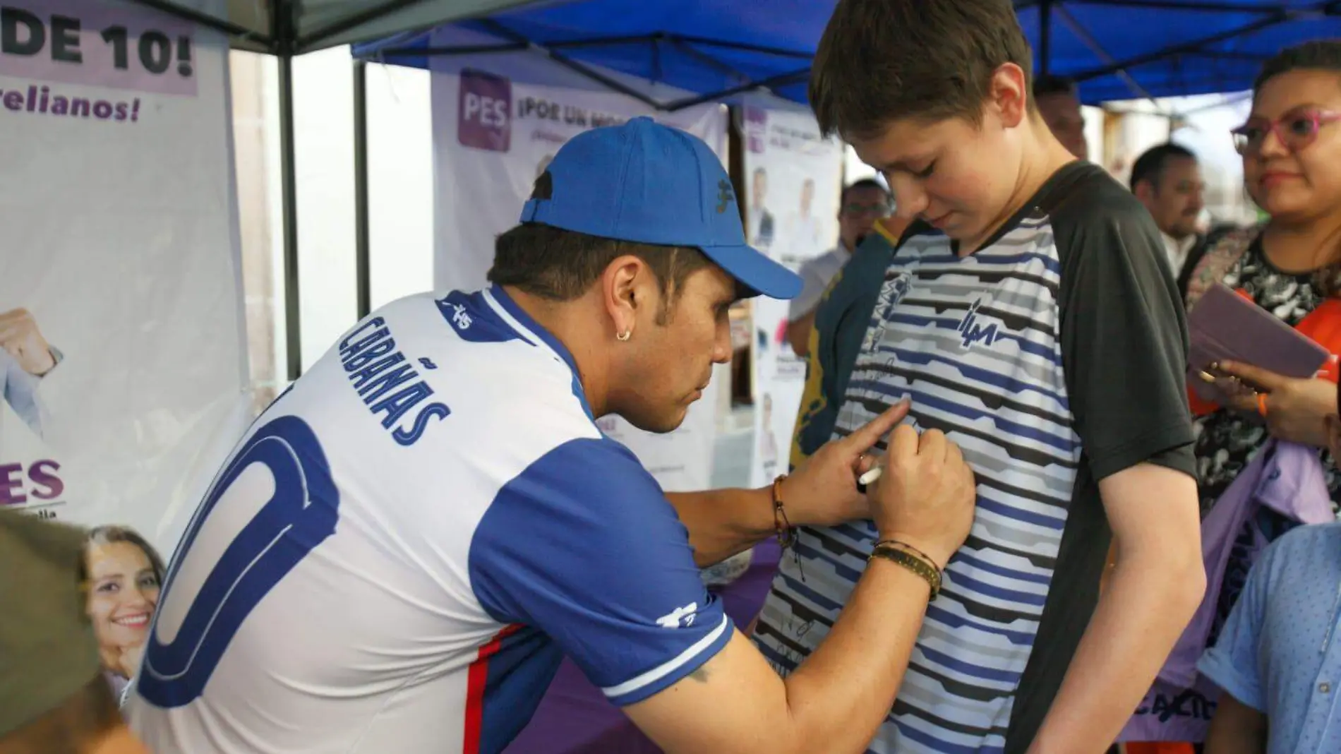 Cabañas autografiando la playera de un niño